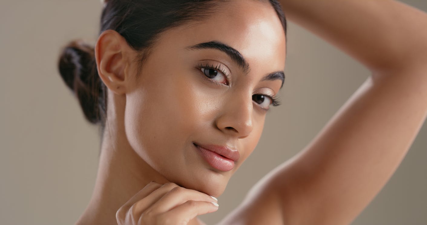 Beautiful Woman with even texture and tone to her skin hair pulled back