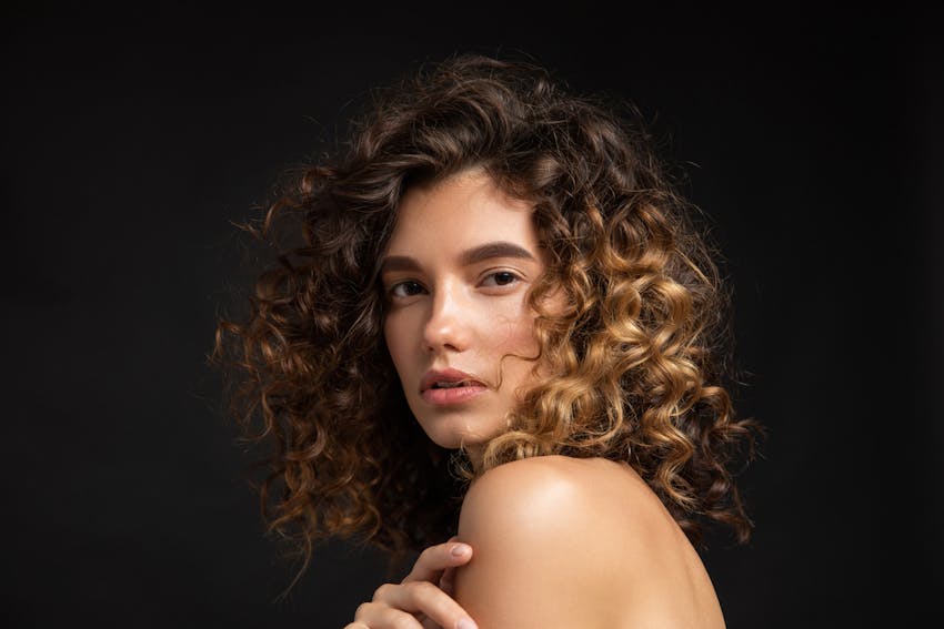woman with dark background and curly hair