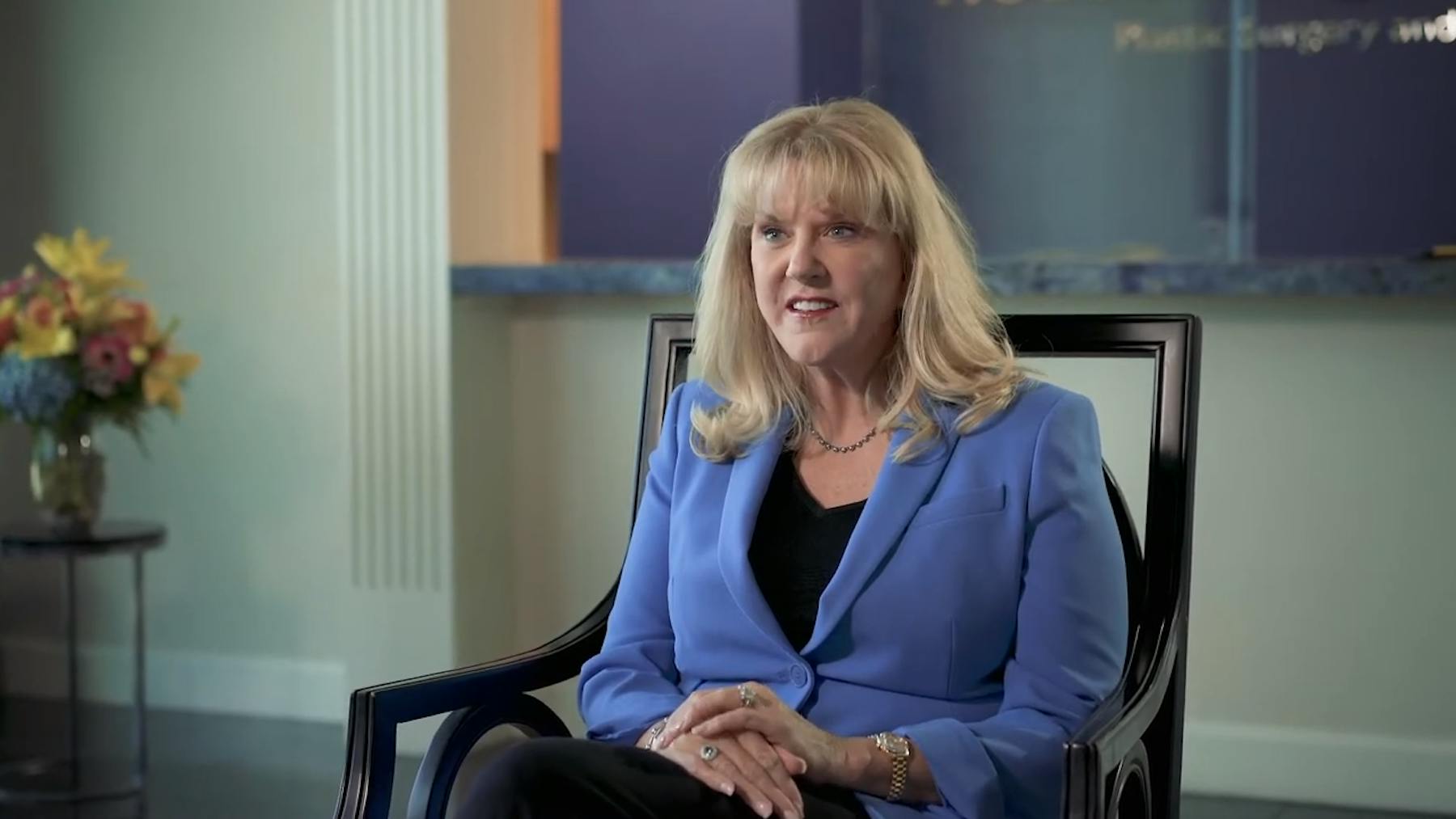 Woman in blue jacket discussing treatment