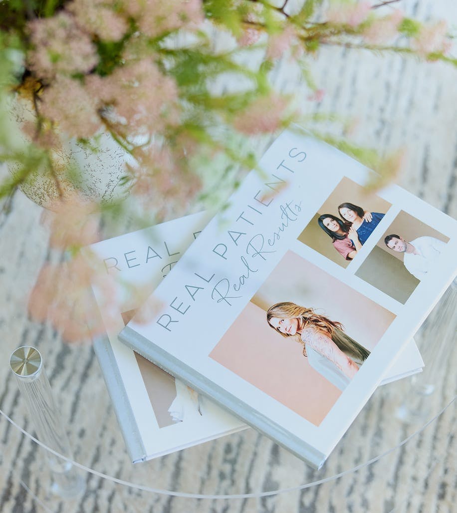 two books and a plant on a glass table