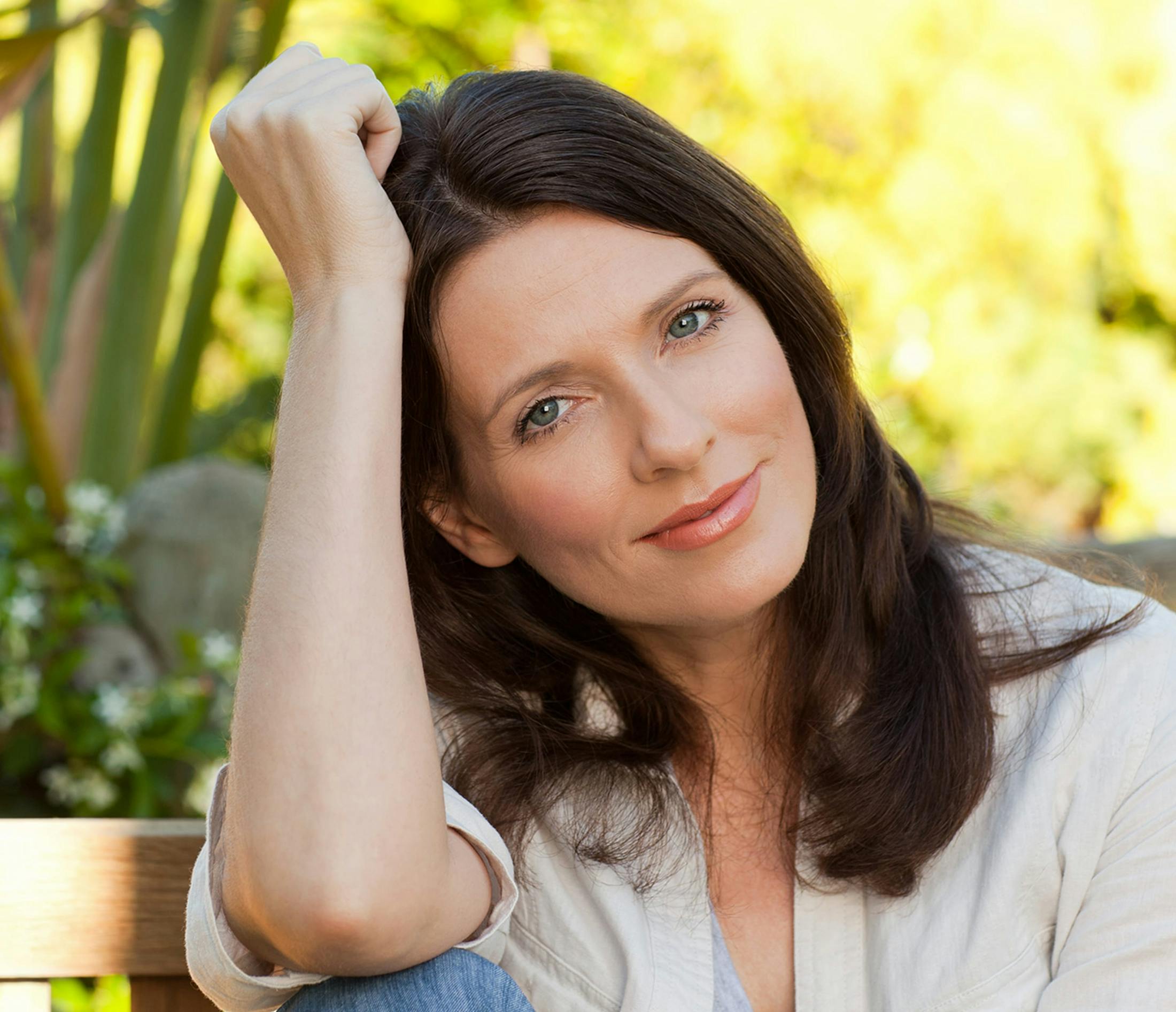 Woman smiling and resting head on arm