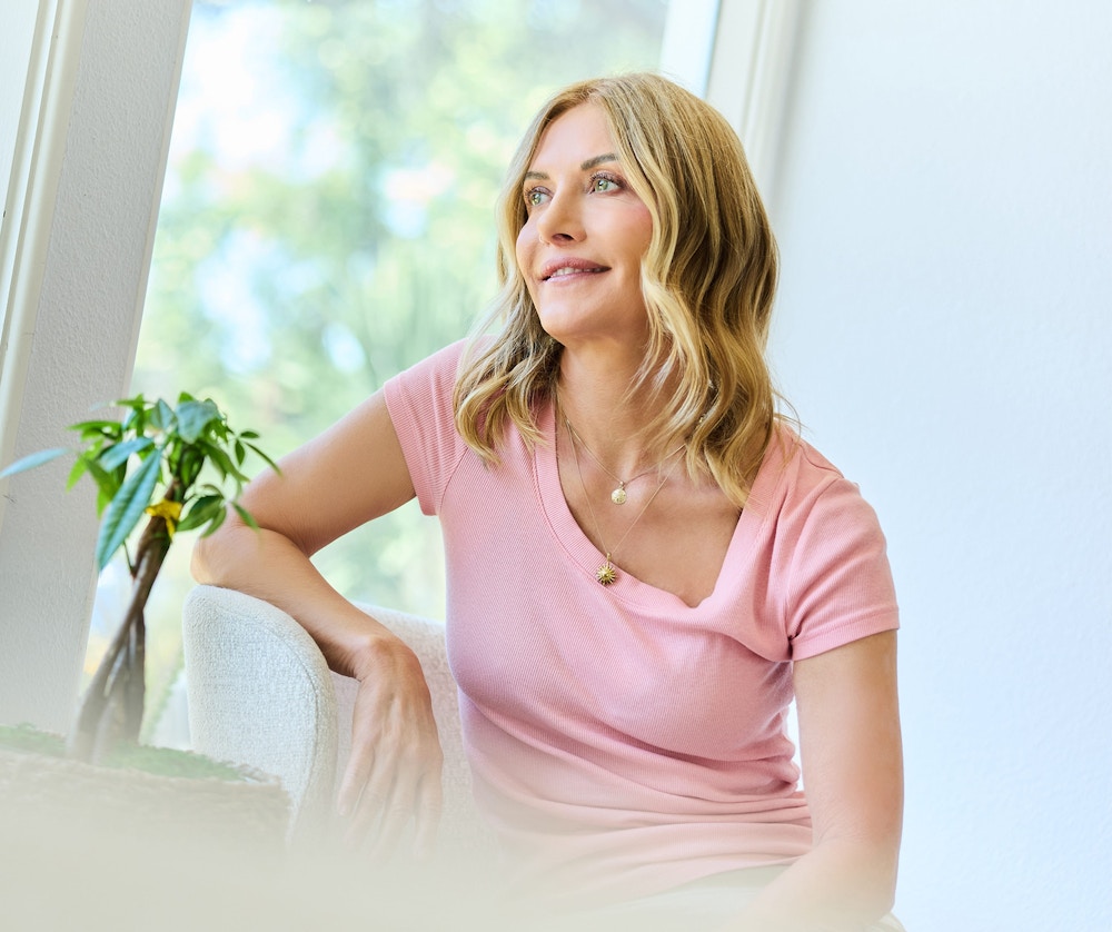 Woman sitting in a chair resting arm on backrest