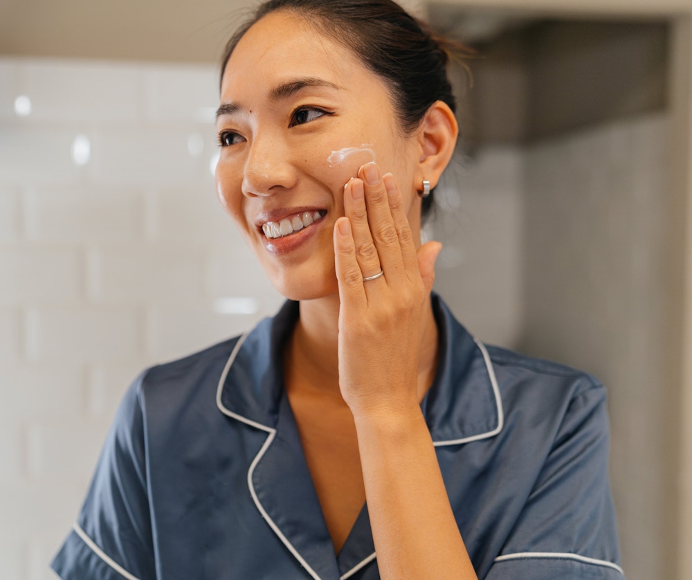 woman putting on skincare product