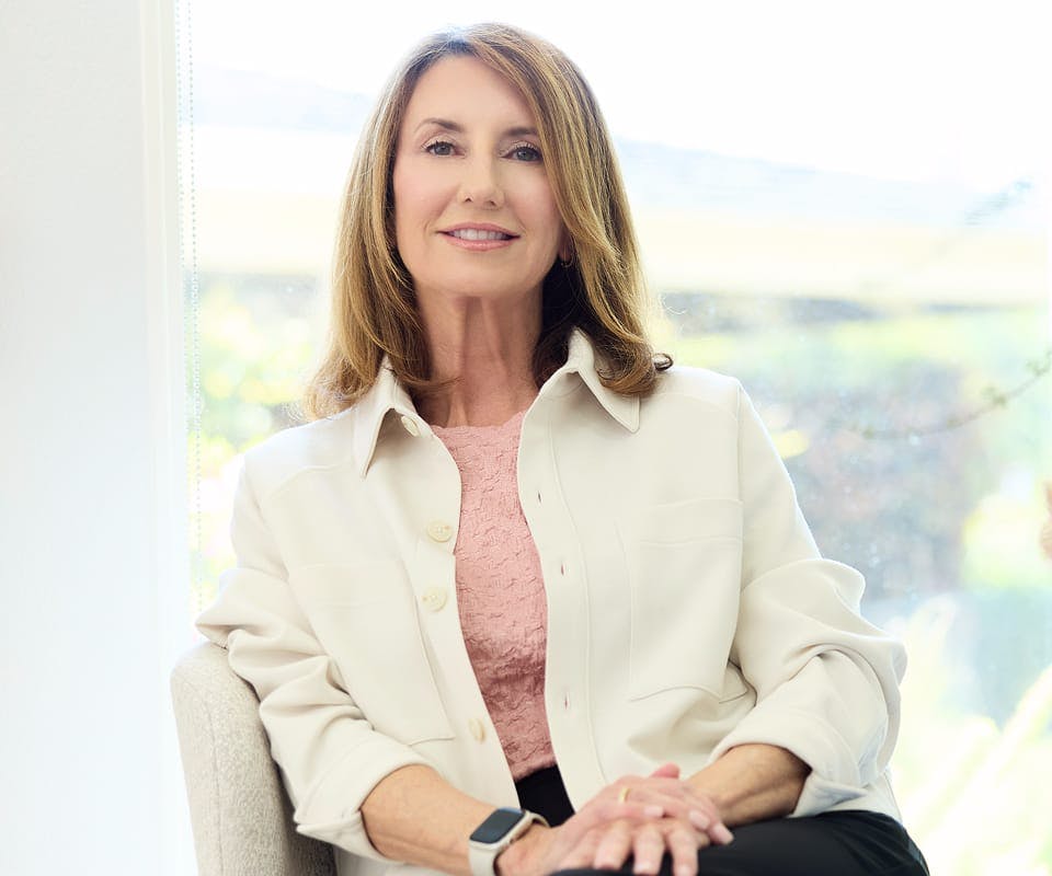 woman wearing a pink shirt and a white jacket