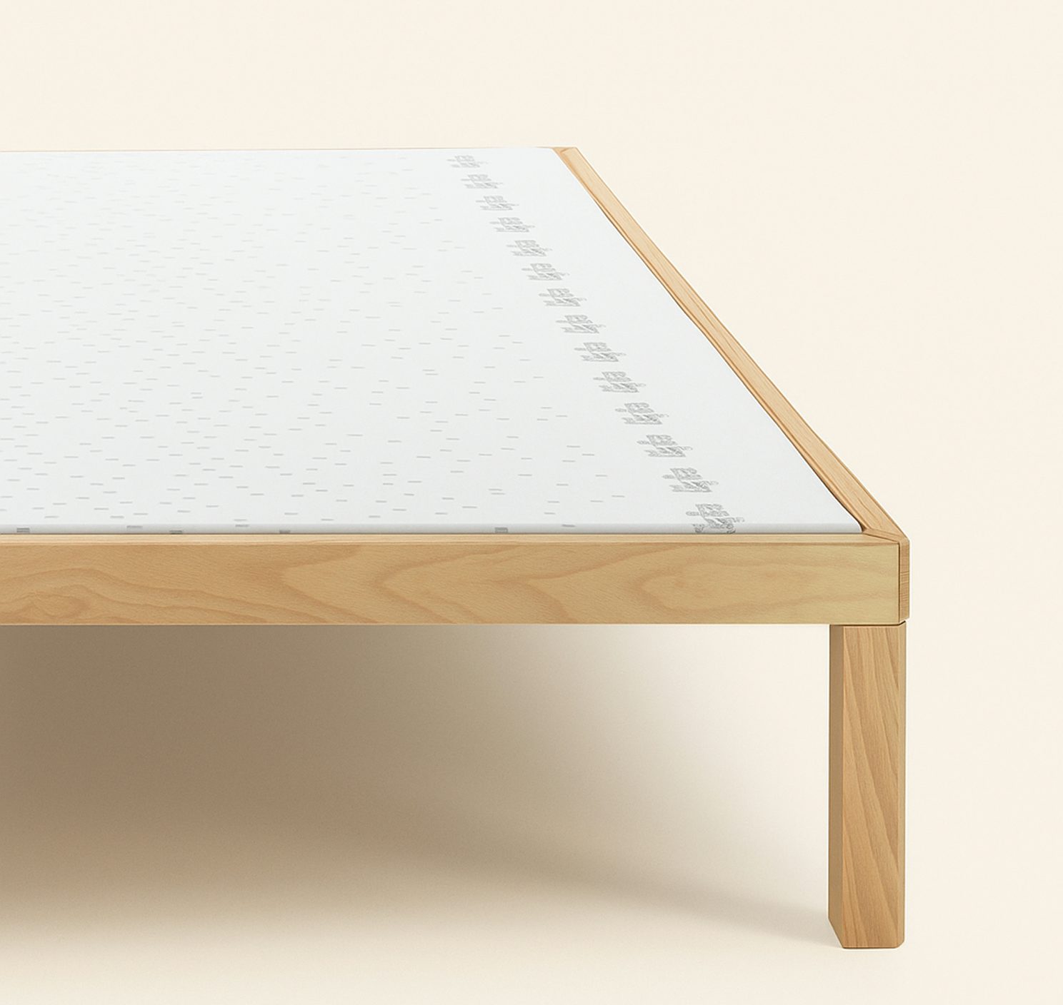 Struttura letto in legno chiaro con materasso bianco bordato da dettagli grigi su sfondo beige chiaro.