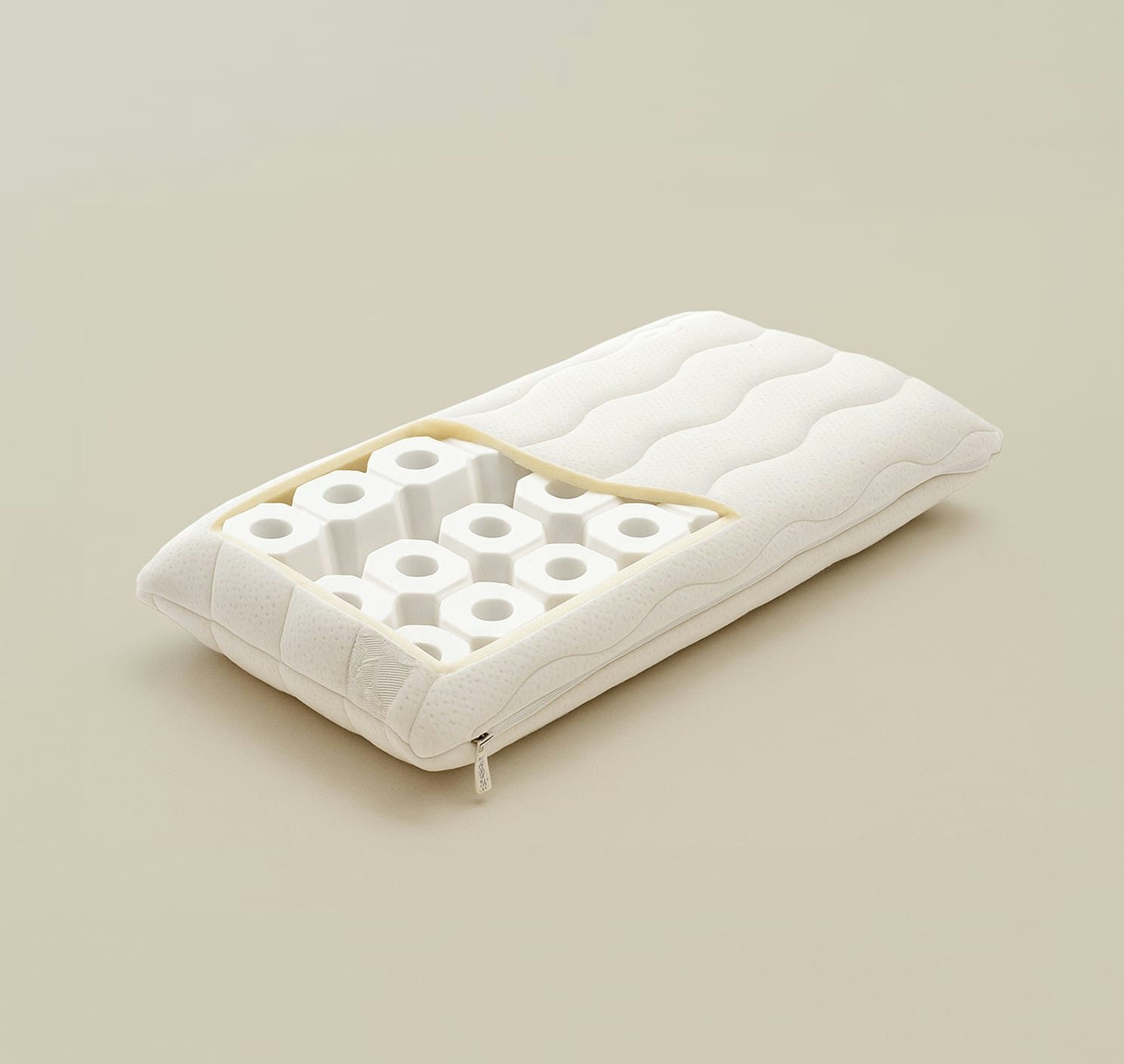 Cuscino bianco sfoderabile con interno a struttura esagonale forata per supporto ergonomico.