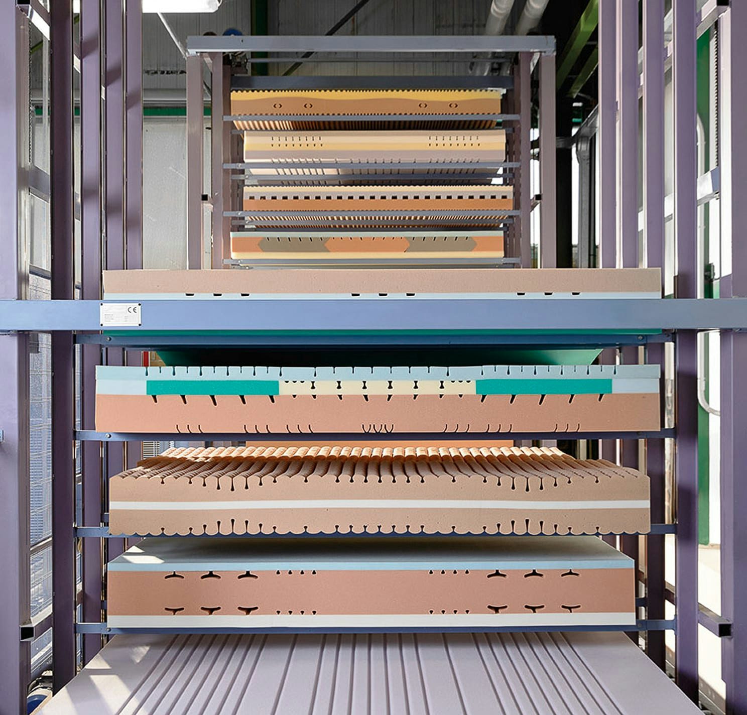 Struttura metallica con diverse lastre di materiale spugnoso di vari colori sovrapposte in laboratorio o stabilimento…