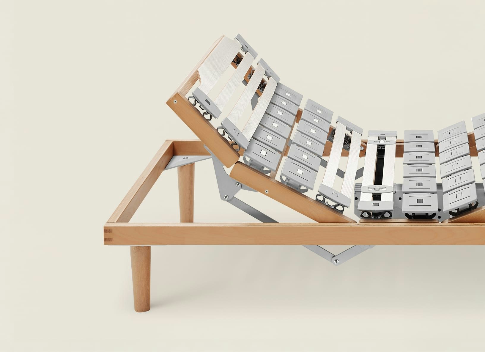 Struttura di letto in legno con doghe regolabili in metallo e plastica, meccanismo alza schienale sollevato.