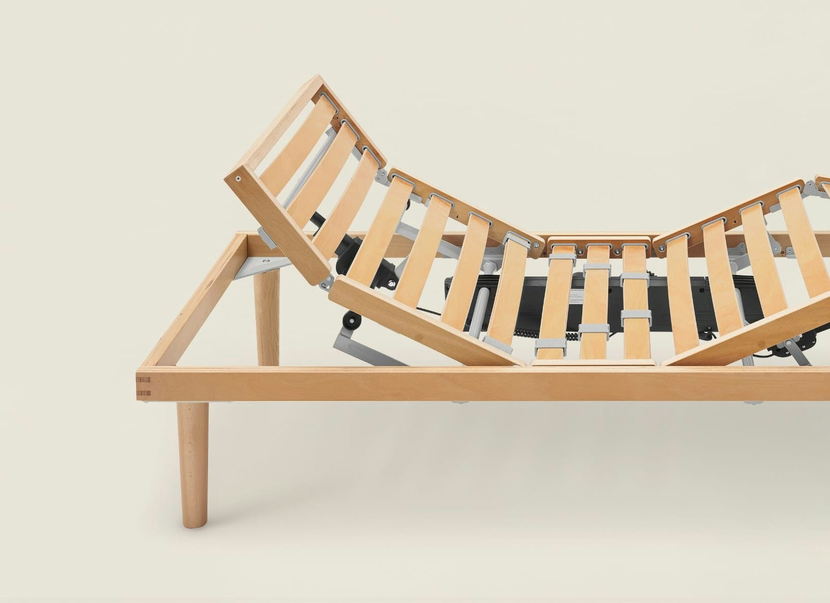 Struttura letto regolabile in legno chiaro con doghe mobili e meccanismo elettrico per sollevare testa e gambe.