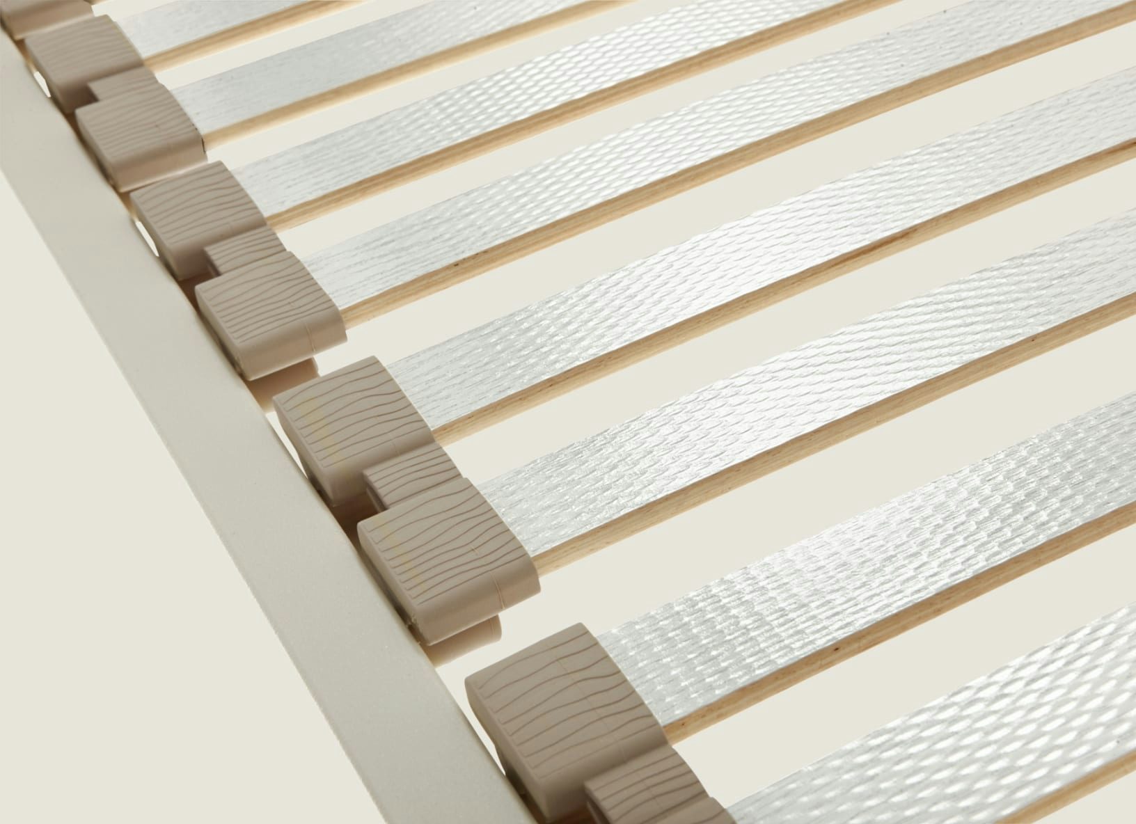 Rete letto con listelli di legno e fasce elastiche trasparenti fissate con supporti beige.