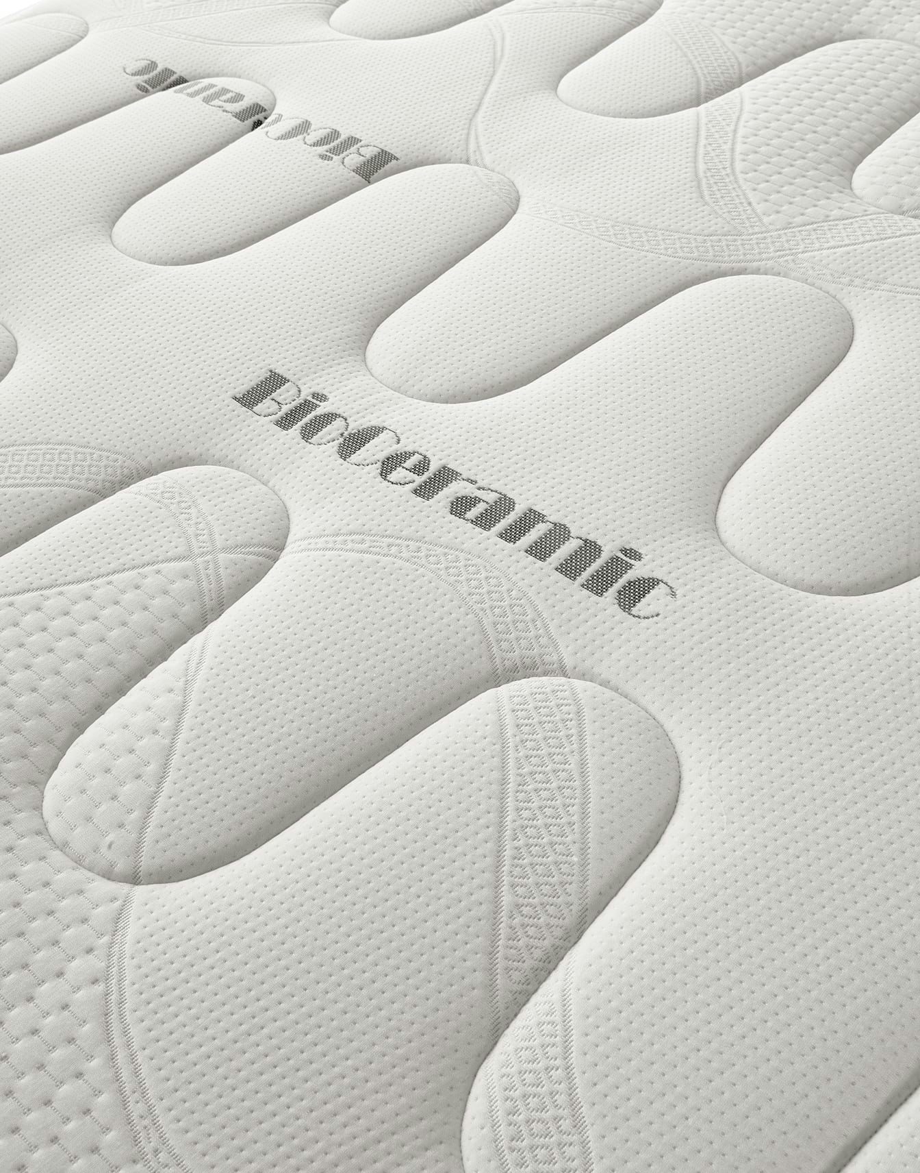 Tessuto bianco trapuntato di un materasso con scritta ricamata BioCeramic e motivo a rilievo morbido al tatto.