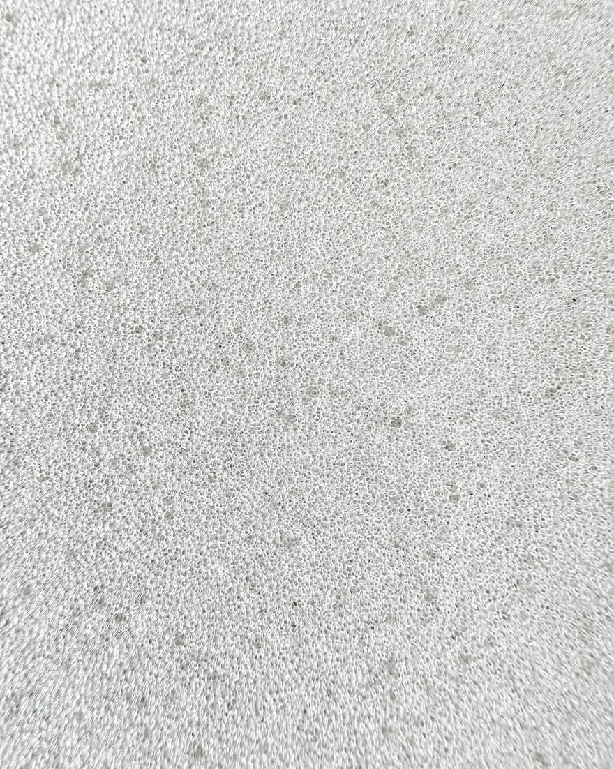 Schiuma bianca molto fine e compatta con minuscole bolle uniformemente distribuite su tutta la superficie.