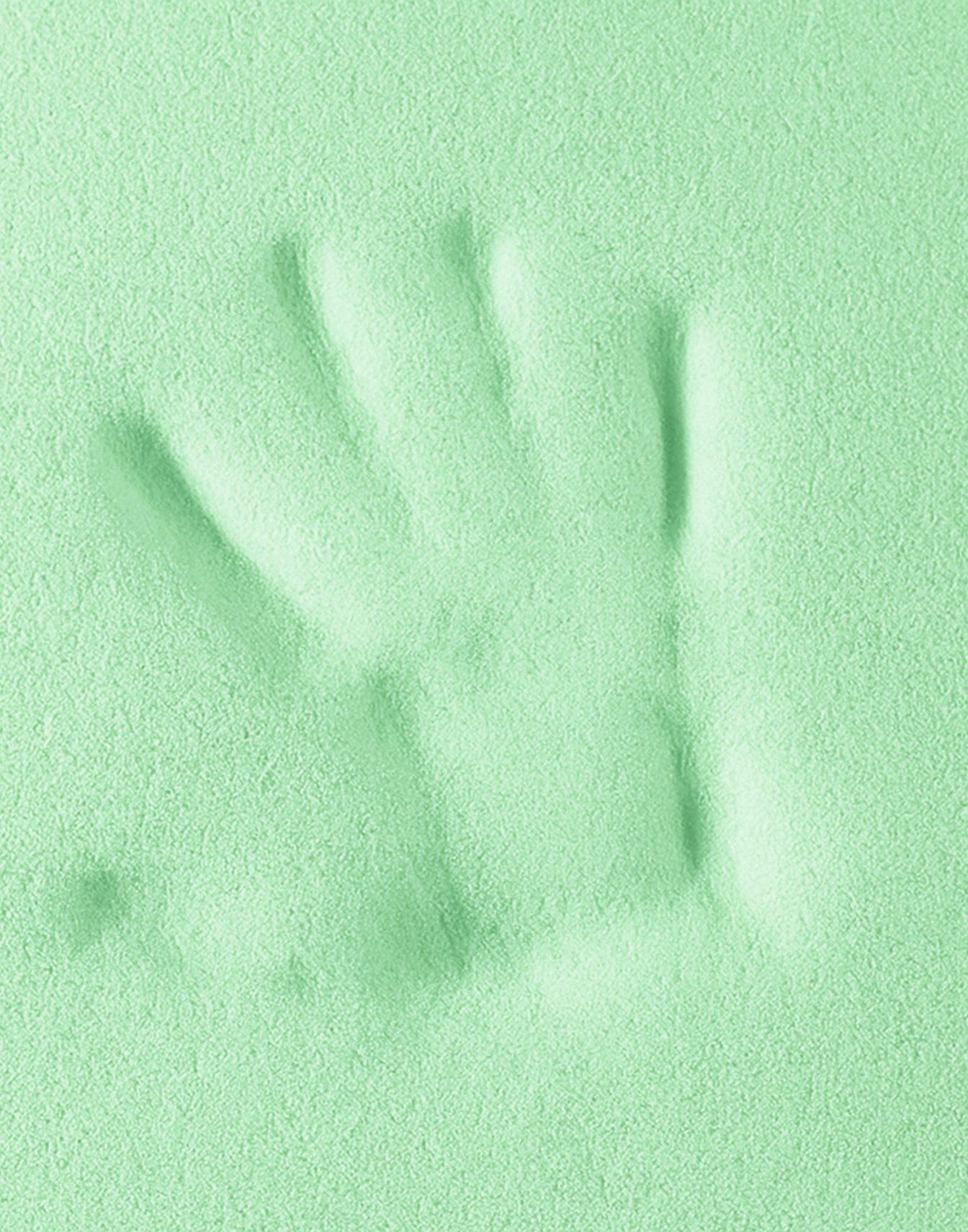 Impronta di mano sinistra impressa su una superficie morbida e verde pastello.