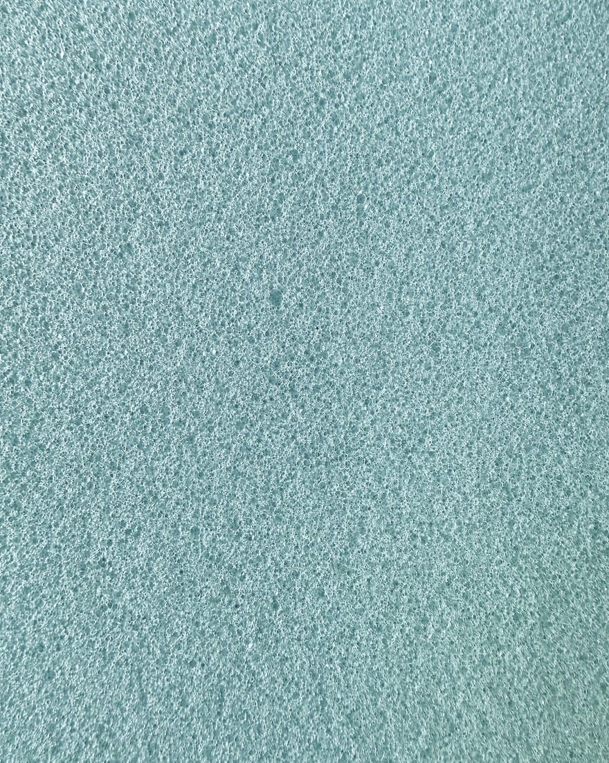 Superficie di schiuma celeste con texture porosa e bolle molto fitte e uniformi.