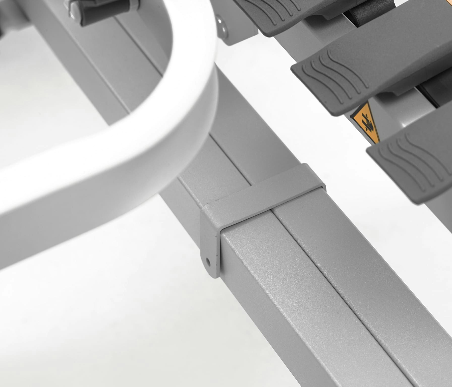 Dettaglio di struttura metallica grigia con clip plastica e pedali neri con superficie antiscivolo.