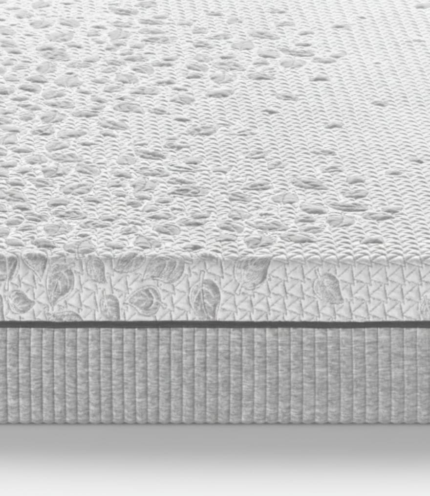 Materasso con superficie trapuntata a motivi floreali e bordo laterale con cuciture verticali grigie.