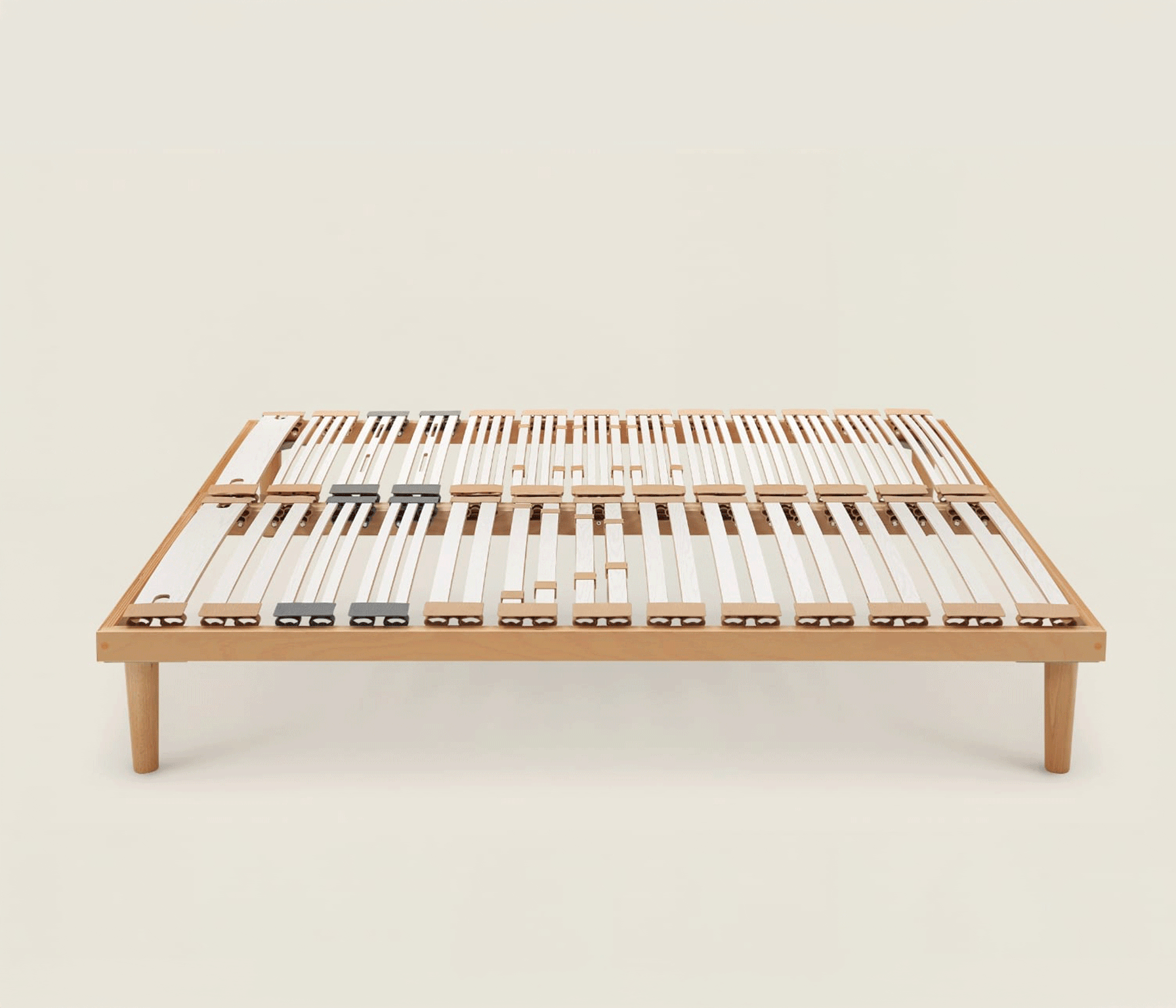 Rete letto in legno con doghe flessibili bianche e reggispinta regolabili per adattare il supporto al corpo.