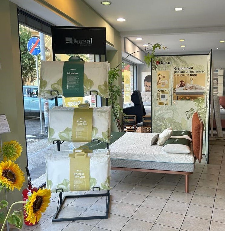Esposizione di guanciali e materassi con decorazioni di girasoli in un negozio di arredamento per il riposo.