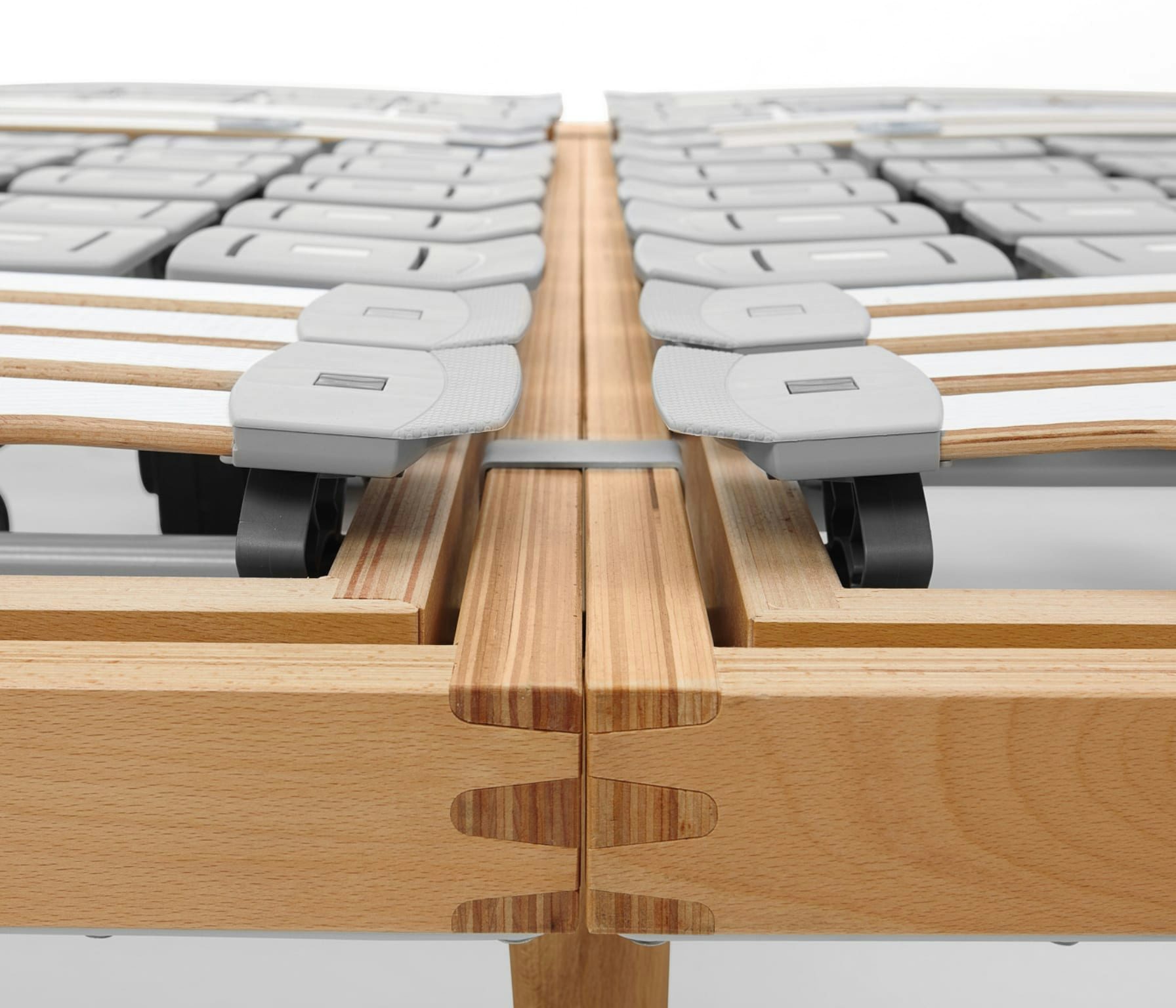 Struttura in legno massello con doghe flessibili di supporto per materasso montate su base regolabile.