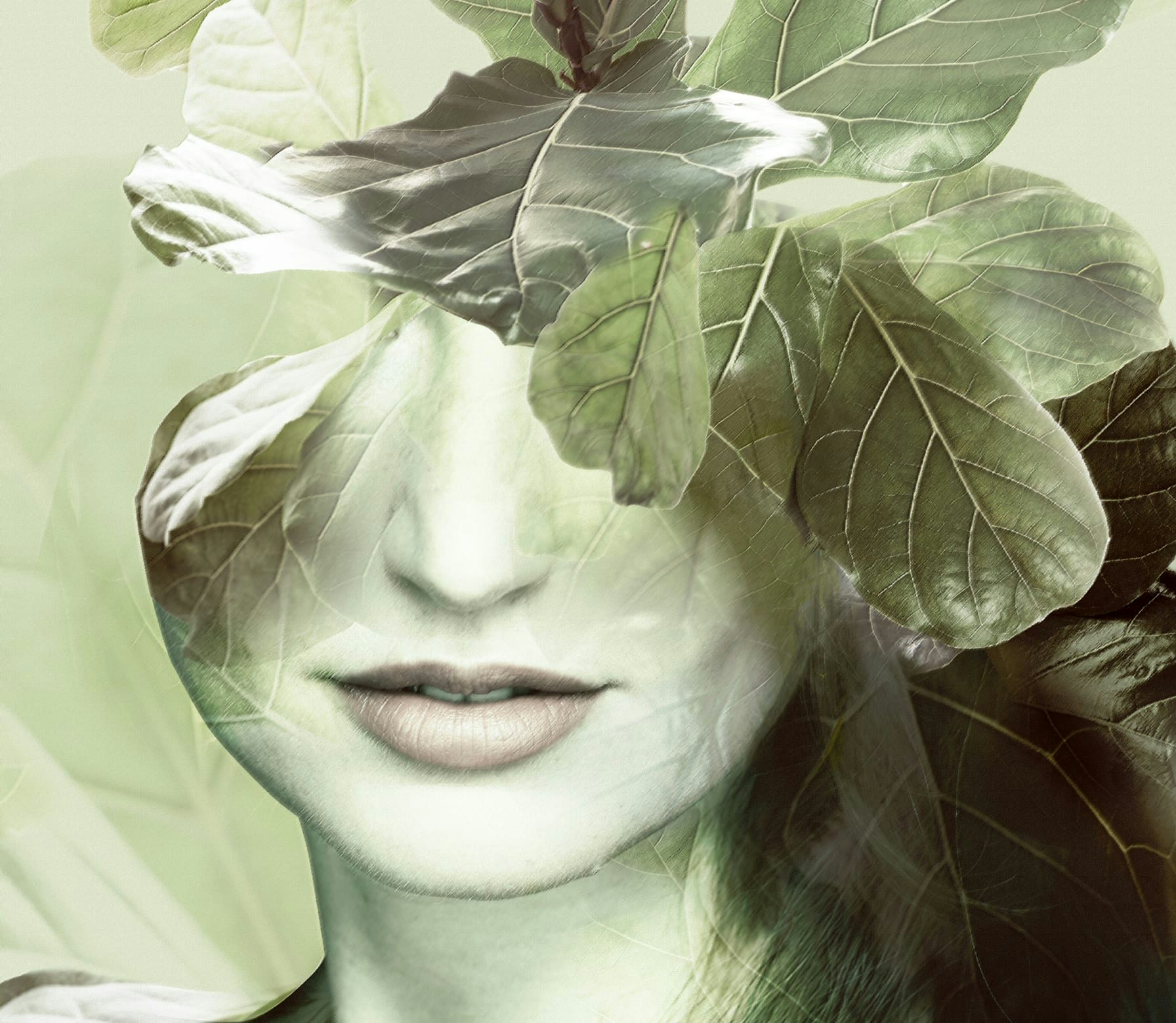 Volto femminile sfumato con foglie verdi sovrapposte che nascondono parte del viso, effetto trasparente e naturale.