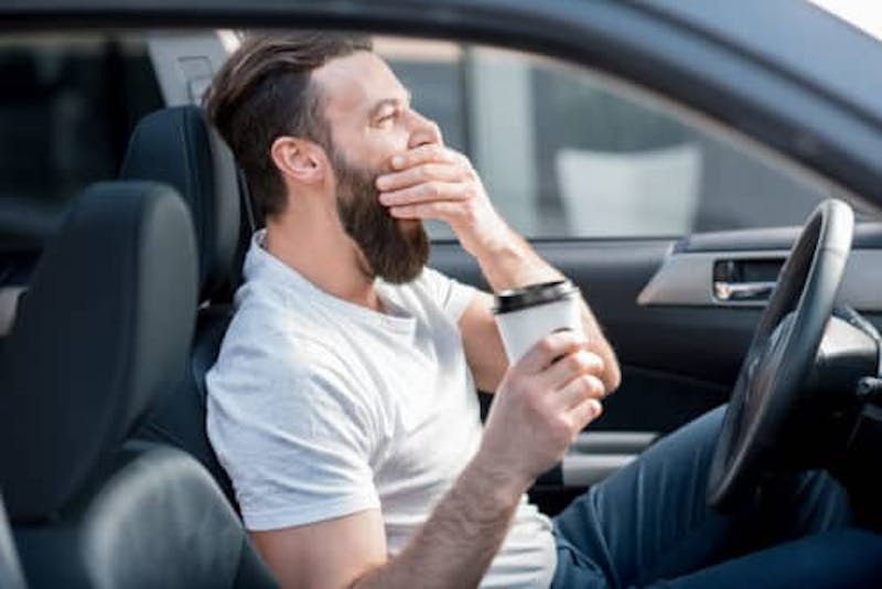 Man yawning in the car