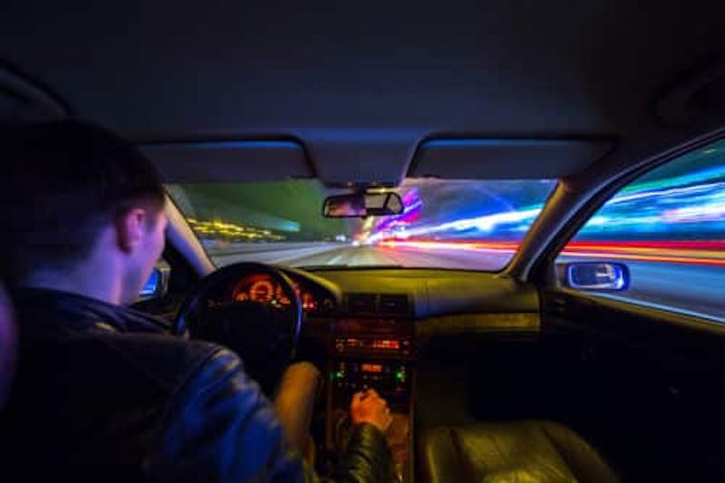 Person driving in a car at night