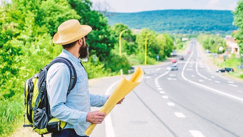 Man with a map looking at a road