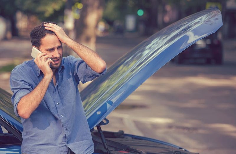 stressed man with broken down car