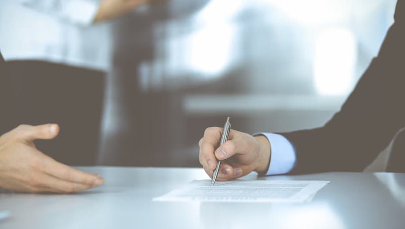 Two people discussing a contract over a desk