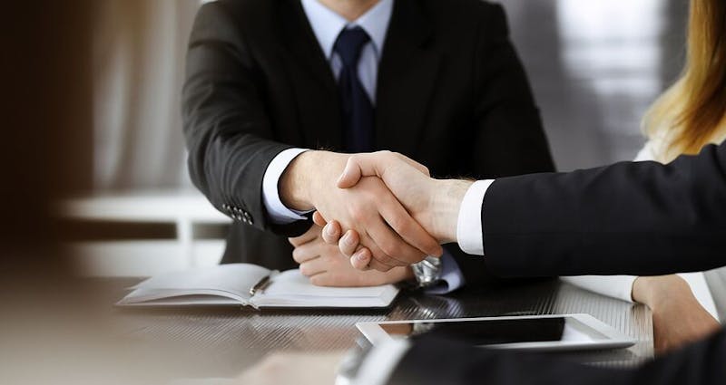 man shaking woman's hand