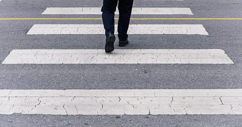 image of feet and legs crossing a crosswalk