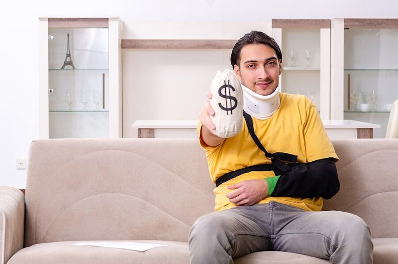 Man with injuries holding a money bag