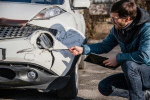 Man looking at his car that has been in a wreck Houston Auto Accident Attorney