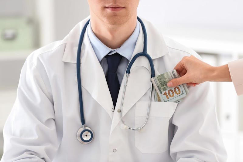 someone handing doctor money