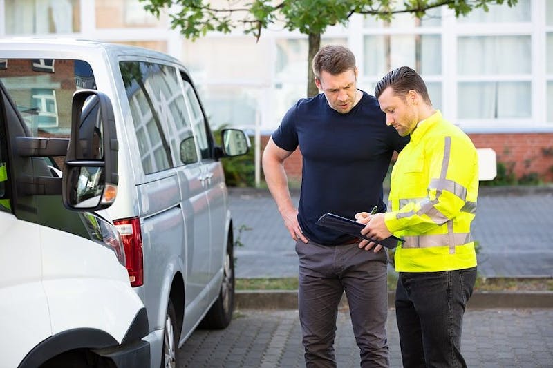 People looking at their cars after an accident