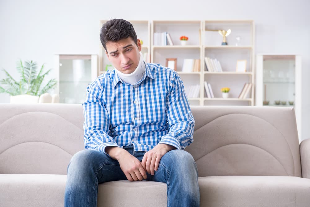 Young man with a neck, spine, or head injury wearing a cervical collar for support and stabilization.