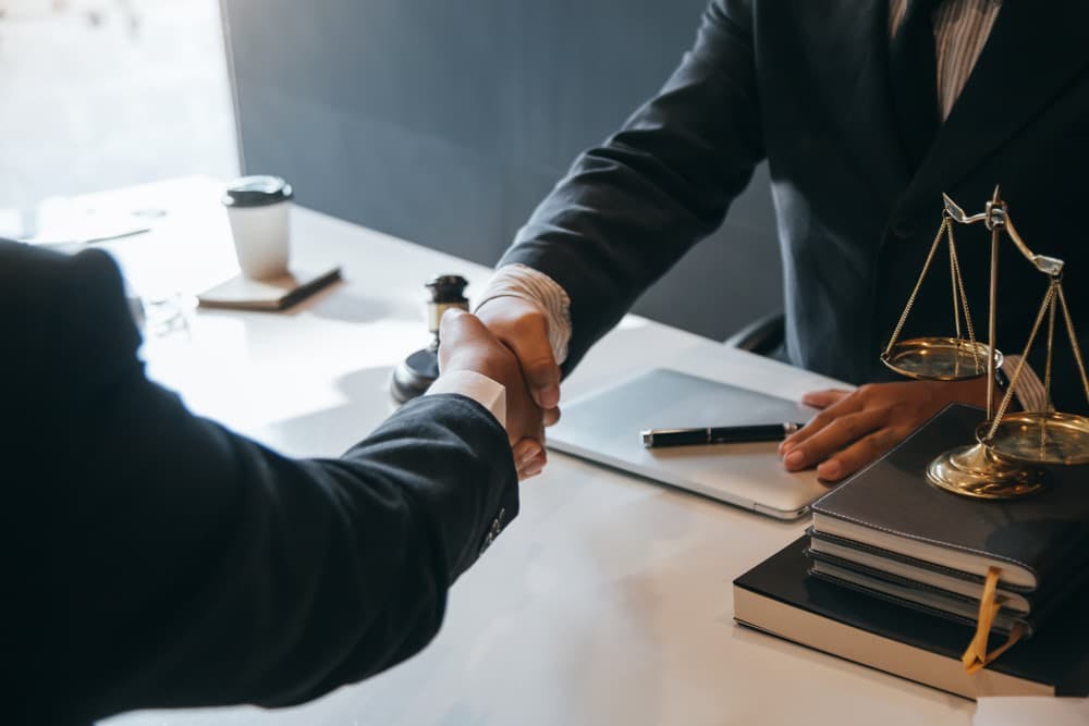 Client shaking hand with car accident lawyer to finalize contract agreement.