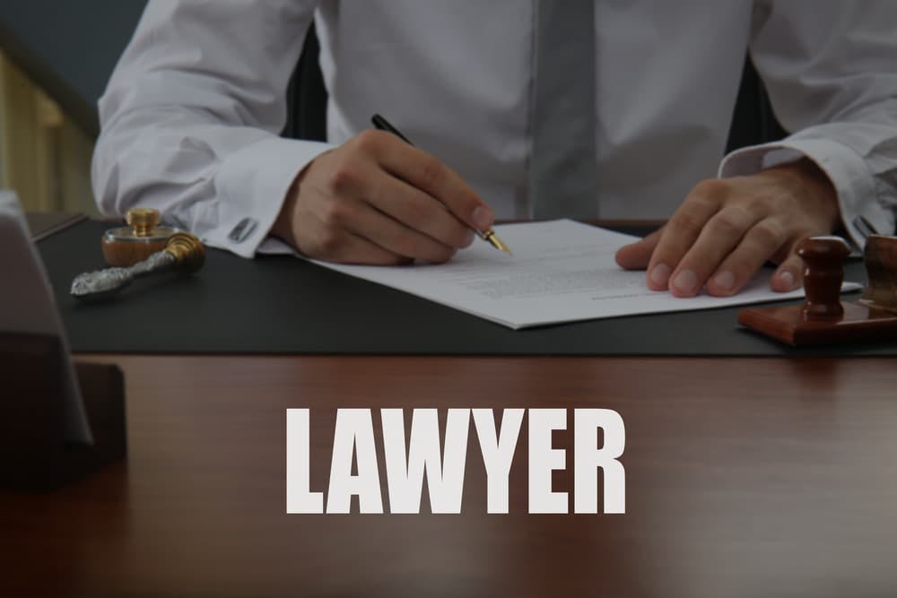 A notary public signing legal documents in an office setting.