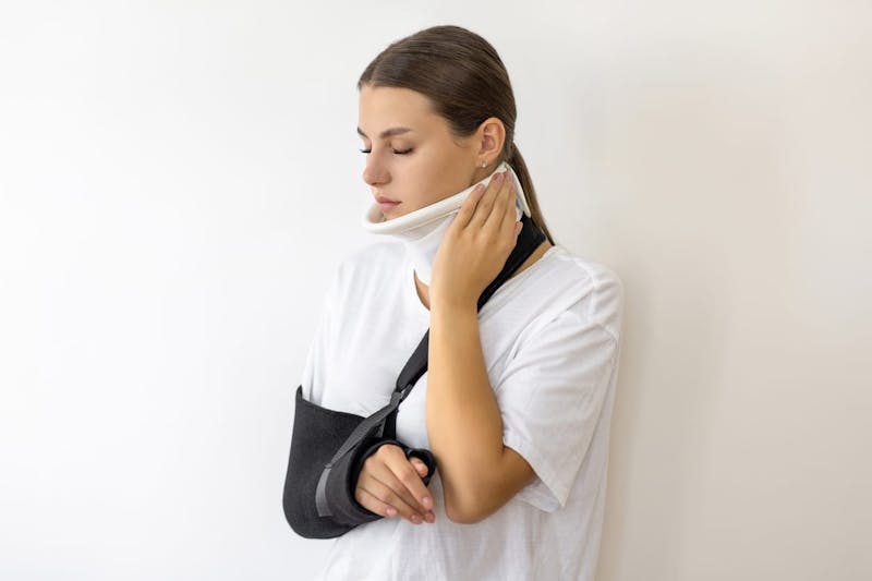 Woman in a neck brace and sling