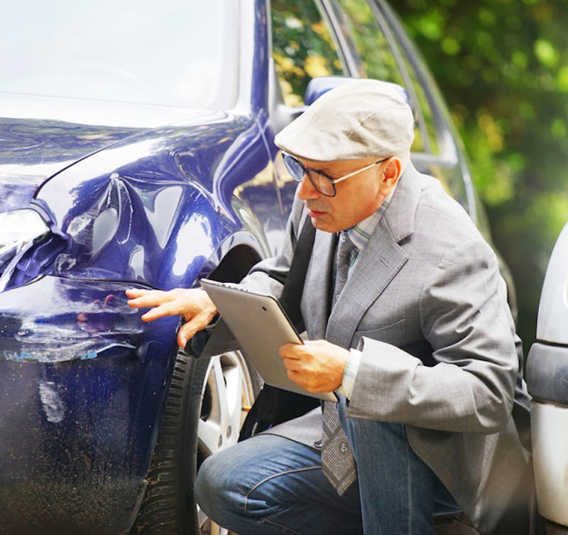 man observing car damage after an accident
