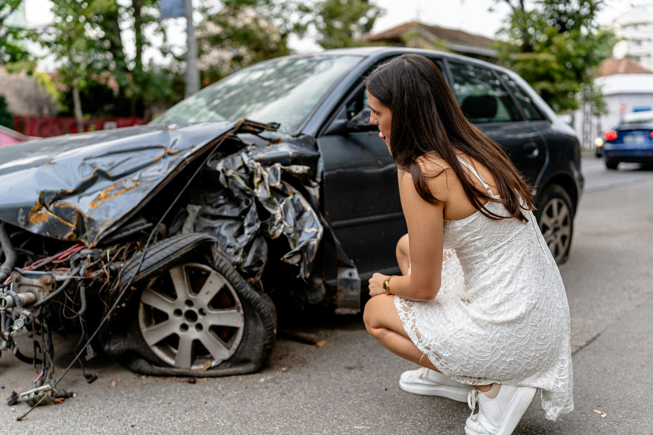 Woman looking at her car after an accident