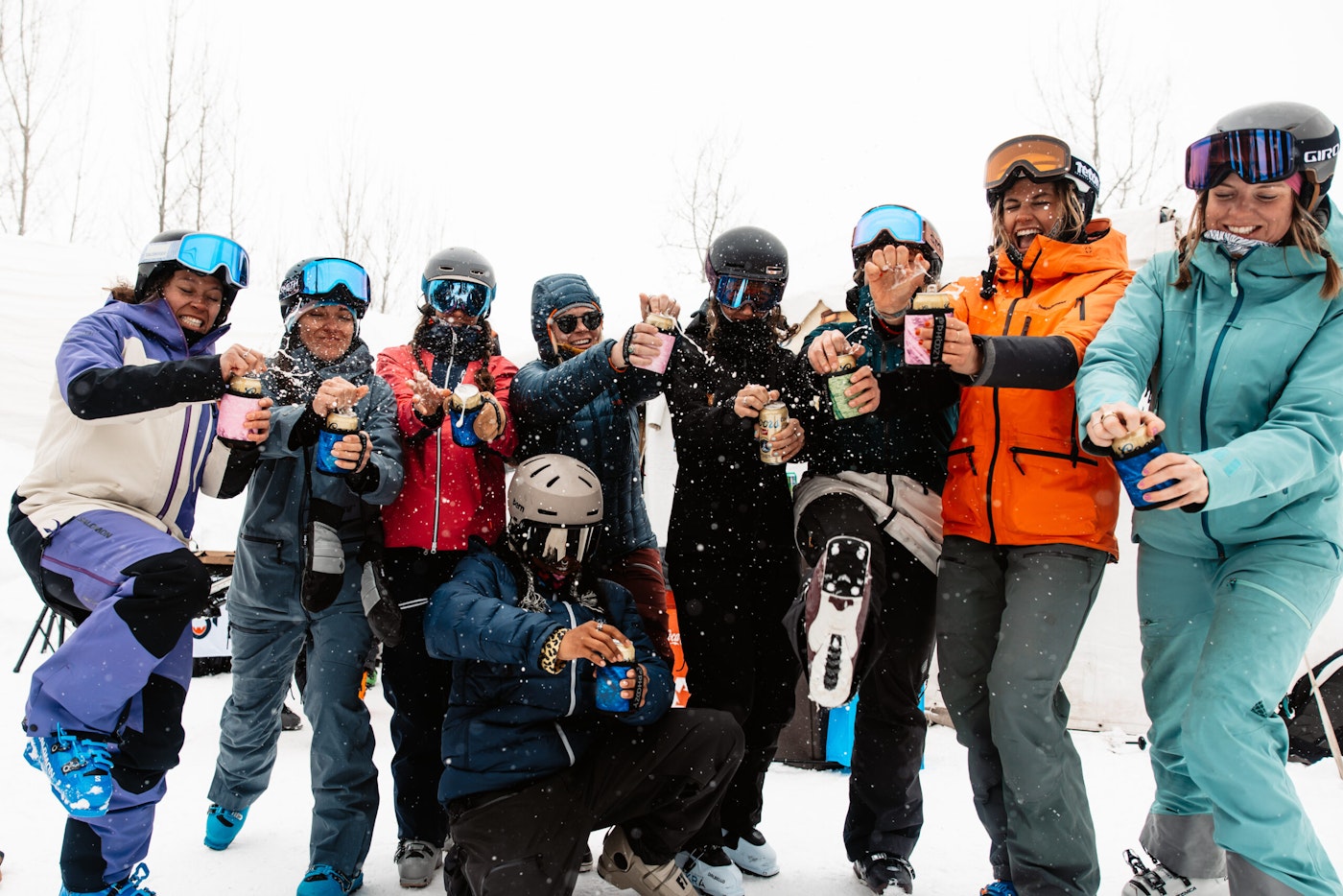 Skiers open cans of beer in ski clothes outside
