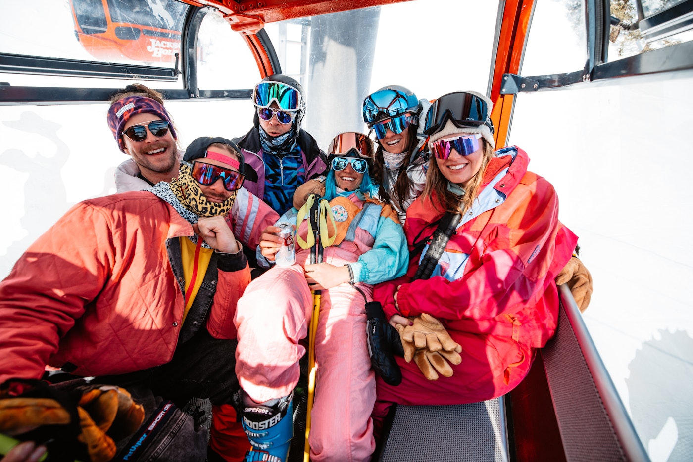 6 skiers in a gondola posing for a photo