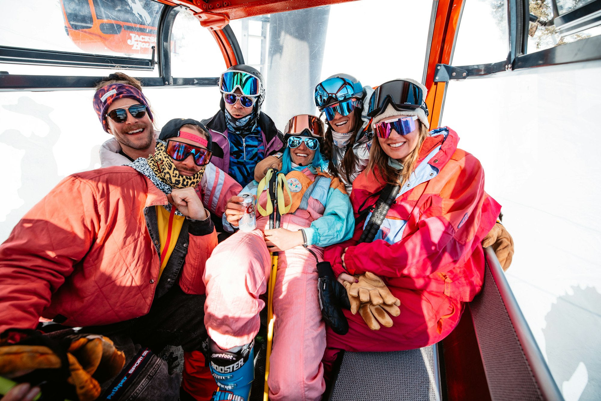 6 skiers in a gondola posing for a photo
