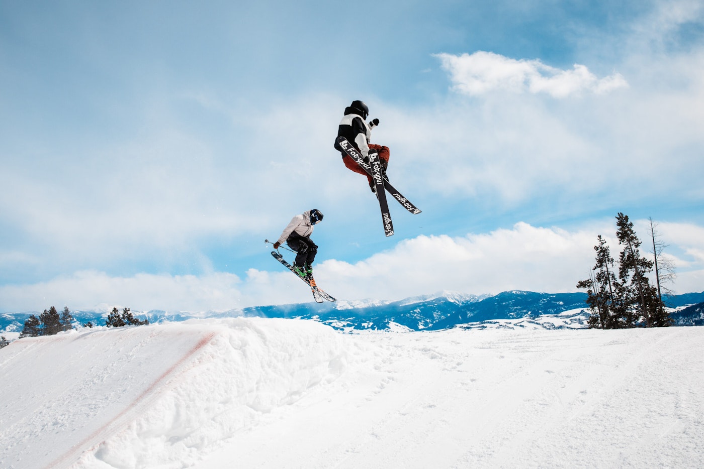 Two skiers jumping in the terrain park