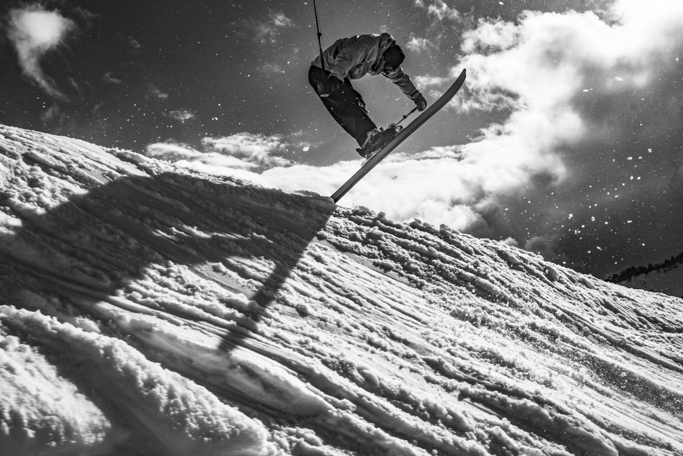 Skier skis over ridge catching air