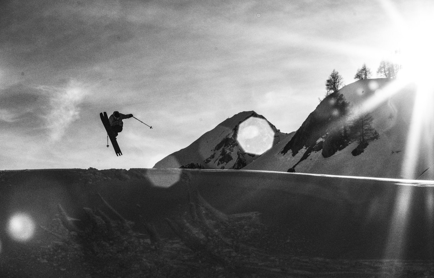 Skier catches air up off a ridge doing a shifty