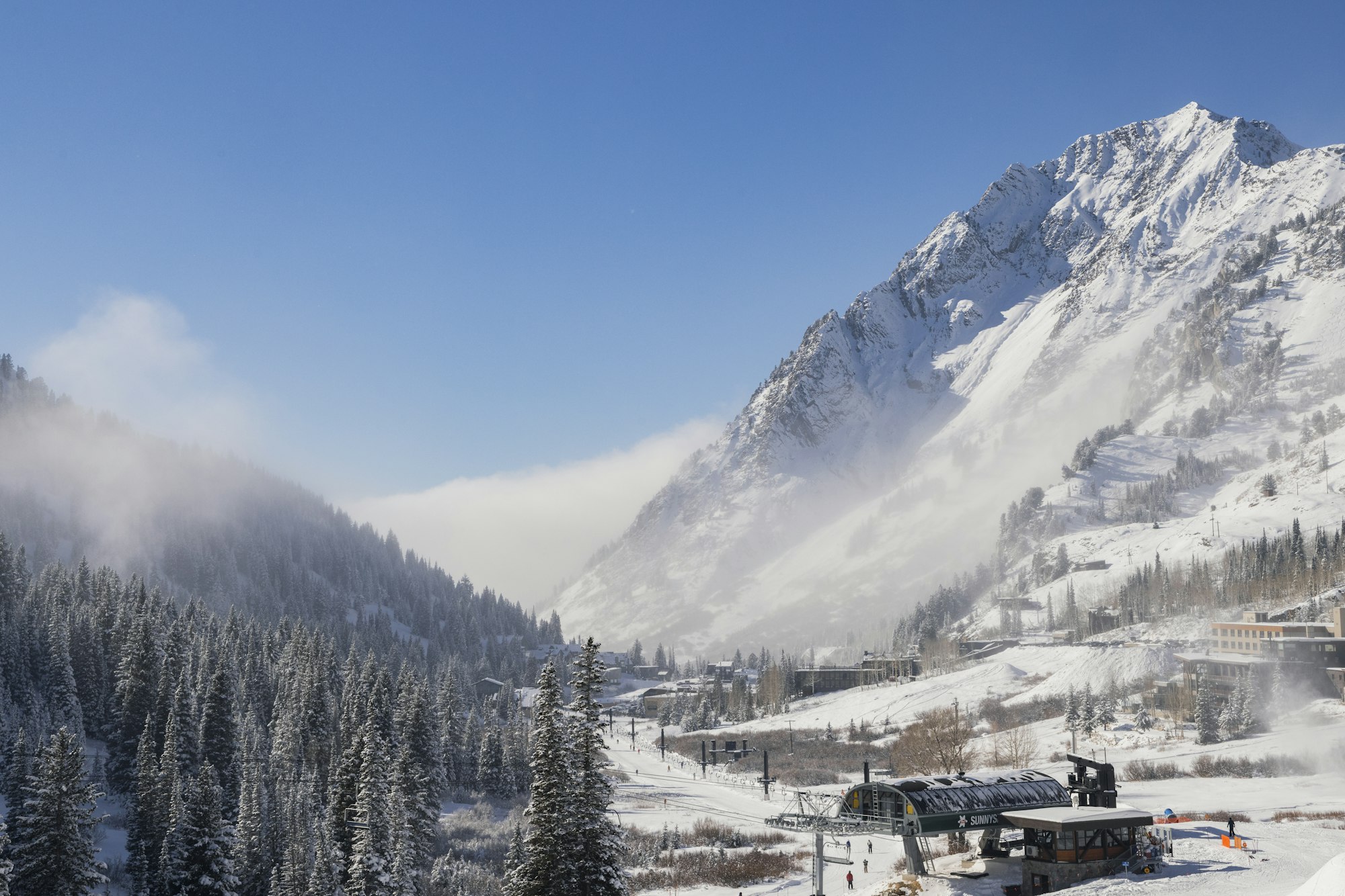 Alta base lift covered in snow with mountain of little cottonwood canyon in the background