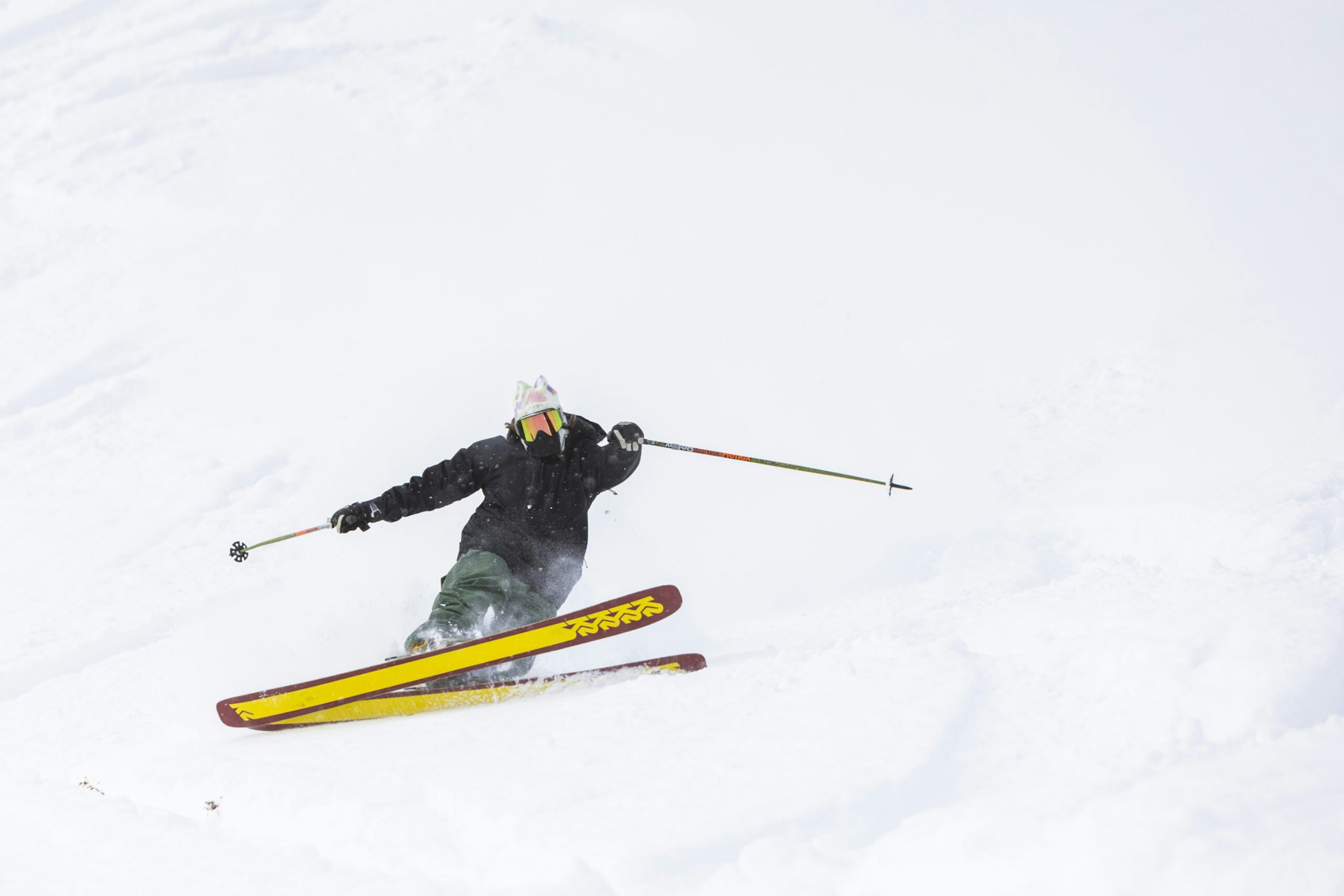 Skier Karl Fostvedt slashing a turn through deep snow