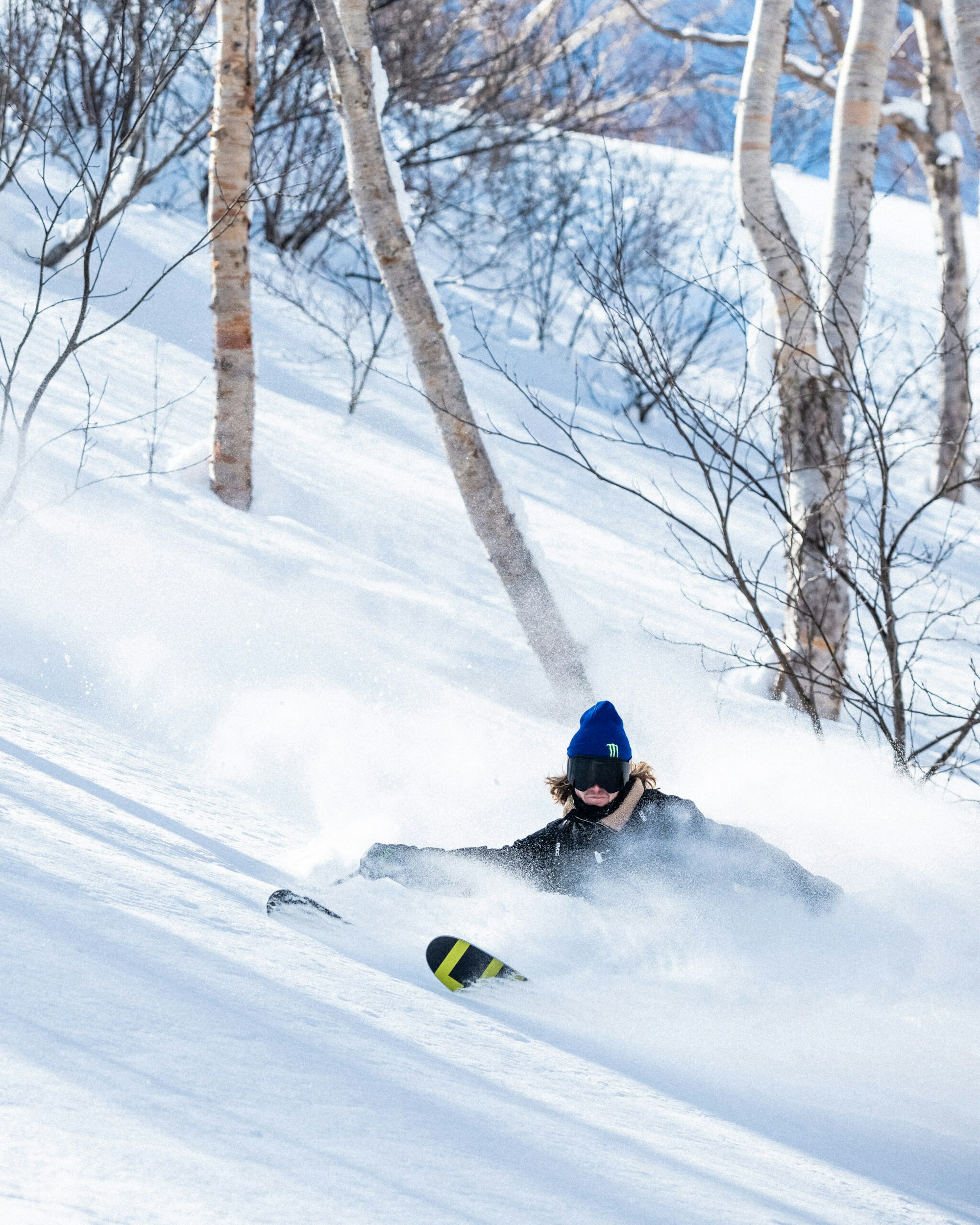 Skier James Woodsy turning in deep snow in the forest